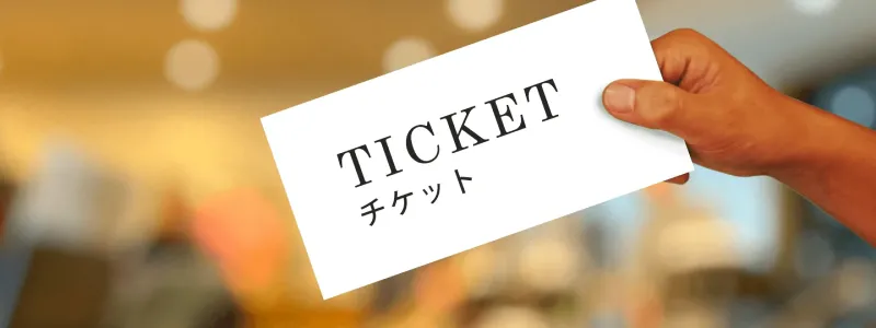 「チケット」と書かれた札を持つ手