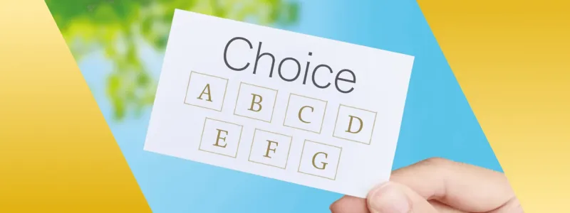 青空と葉を背景に「Choice」のカードを持つ手